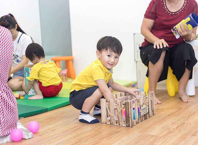 Children playing with a tutor nearby
